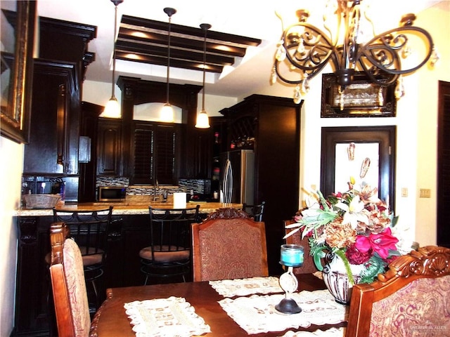 dining space with beamed ceiling and a chandelier