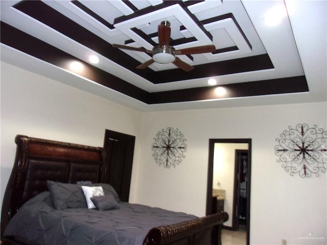 bedroom with a tray ceiling and ceiling fan