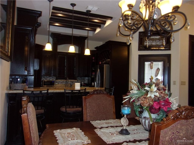 dining area with beam ceiling, a notable chandelier, and coffered ceiling