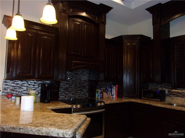 kitchen with decorative backsplash, appliances with stainless steel finishes, dark brown cabinets, and hanging light fixtures