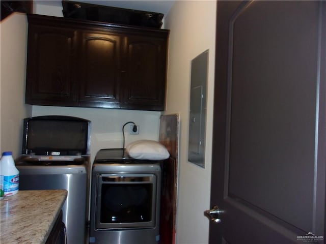 clothes washing area with cabinets and independent washer and dryer