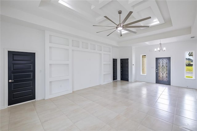 interior space featuring a tray ceiling and ceiling fan with notable chandelier