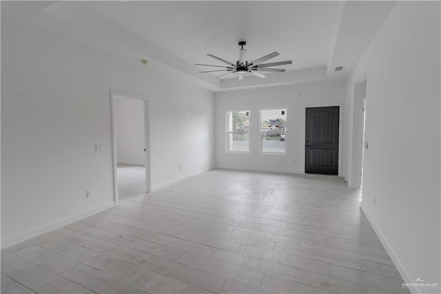 2005 Hacienda Cir, Harlingen, TX 78552 - empty room featuring a ceiling fan, baseboards, visible vents, a raised ceiling, and light wood-style floors