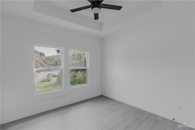 2005 Hacienda Cir, Harlingen, TX 78552 - unfurnished room with light wood finished floors, a raised ceiling, baseboards, and ceiling fan