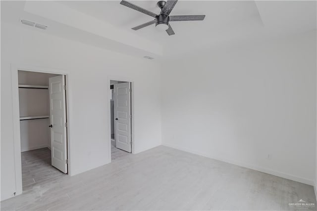 2005 Hacienda Cir, Harlingen, TX 78552 - unfurnished bedroom featuring a closet, visible vents, a spacious closet, a ceiling fan, and light wood-style floors