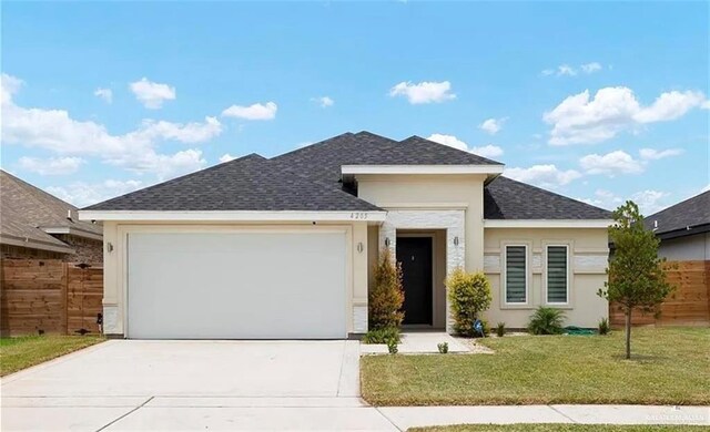 view of front of home featuring roof with shingles, concrete driveway, a front yard, and stucco siding