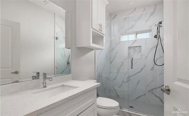 full bath with a marble finish shower, toilet, and vanity