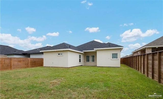 back of property with a yard, a fenced backyard, and stucco siding