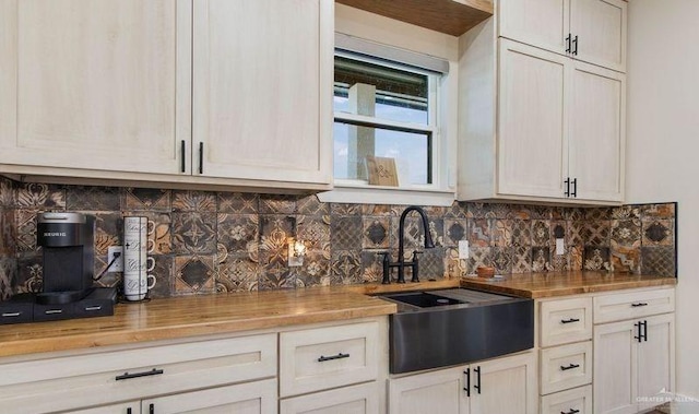 kitchen featuring wood counters, backsplash, and sink