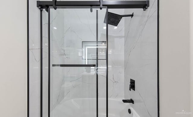 bathroom with shower / bath combination with glass door