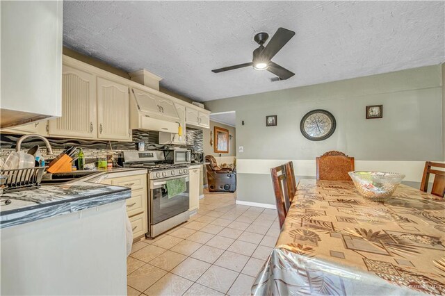 2865 E Mile 9 1/2 N, Donna, TX 78537 - kitchen featuring stainless steel gas range, ceiling fan, light tile patterned floors, a textured ceiling, and backsplash