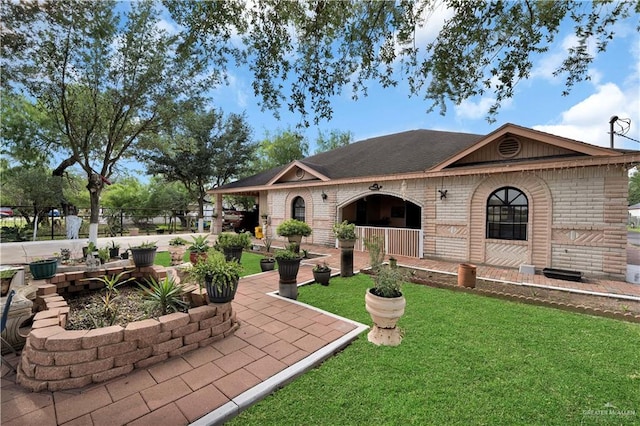 2865 E Mile 9 1/2 N, Donna, TX 78537 - view of front of house featuring brick siding, a front lawn, and a porch