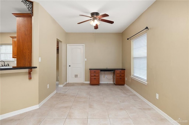 tiled spare room with ceiling fan and sink