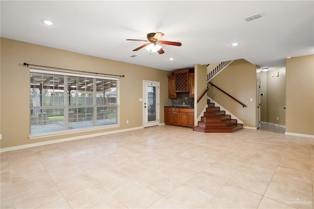 unfurnished living room featuring ceiling fan and light tile patterned floors