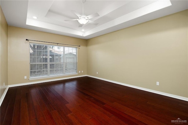 spare room featuring hardwood / wood-style flooring, a raised ceiling, and ceiling fan