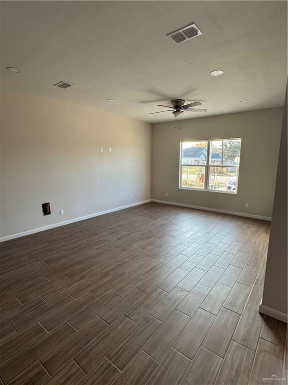 spare room featuring ceiling fan and dark wood-type flooring