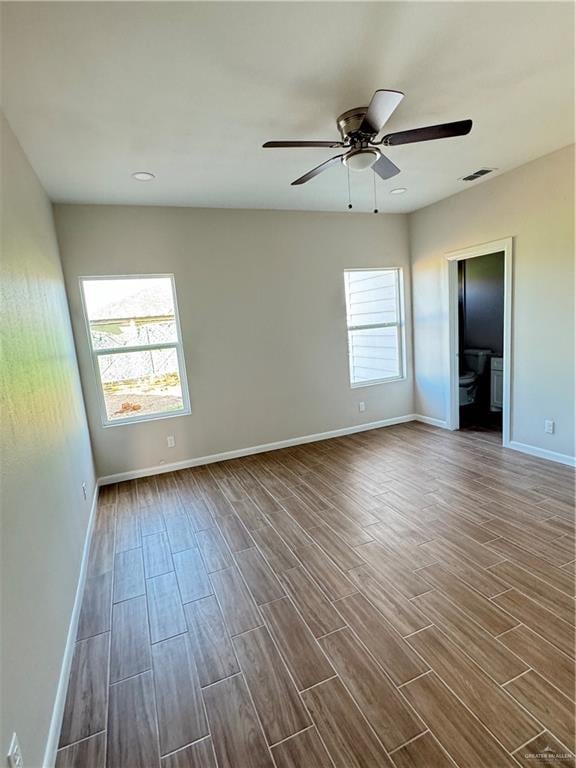 spare room with ceiling fan and dark wood-type flooring