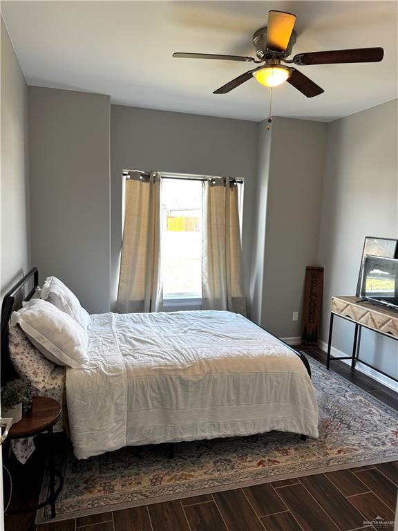 bedroom featuring a ceiling fan, baseboards, and wood finished floors