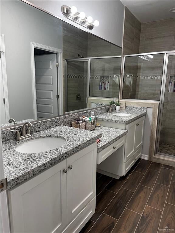 bathroom with a stall shower, vanity, and wood finish floors