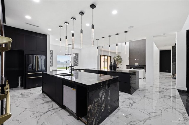 4648 Estancia Pkwy, Mcallen, TX 78504 - kitchen with a spacious island, high end black refrigerator, modern cabinets, dark cabinets, and recessed lighting