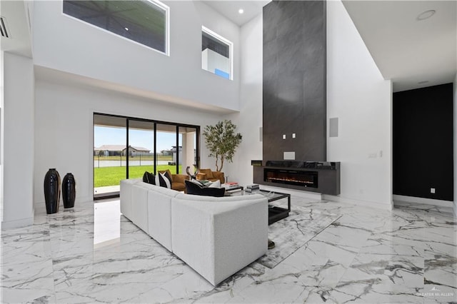 4648 Estancia Pkwy, Mcallen, TX 78504 - living area featuring marble tiled flooring, a towering ceiling, a fireplace, and recessed lighting