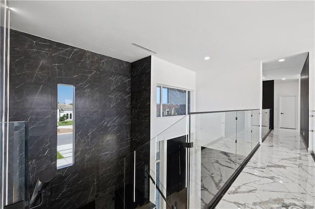 4648 Estancia Pkwy, Mcallen, TX 78504 - hallway featuring marble tiled flooring, stone wall, and recessed lighting