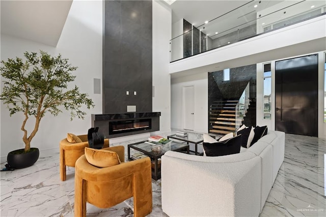 4648 Estancia Pkwy, Mcallen, TX 78504 - living area featuring a high ceiling, marble tiled floors, stairway, and a high end fireplace