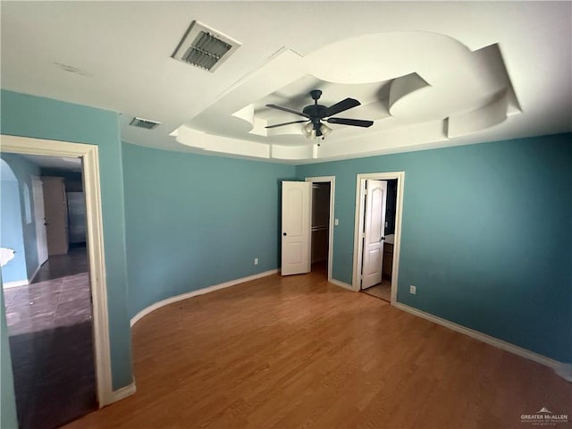 1908 W 42nd St, Mission, TX 78573 - unfurnished bedroom featuring a tray ceiling, wood finished floors, baseboards, and a ceiling fan