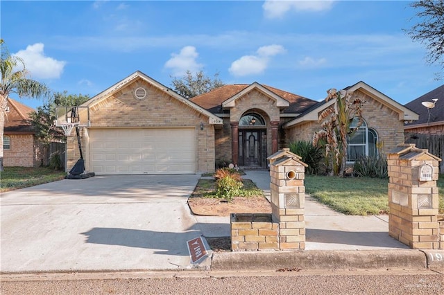 1908 W 42nd St, Mission, TX 78573 - view of front facade featuring a garage, brick siding, and concrete driveway