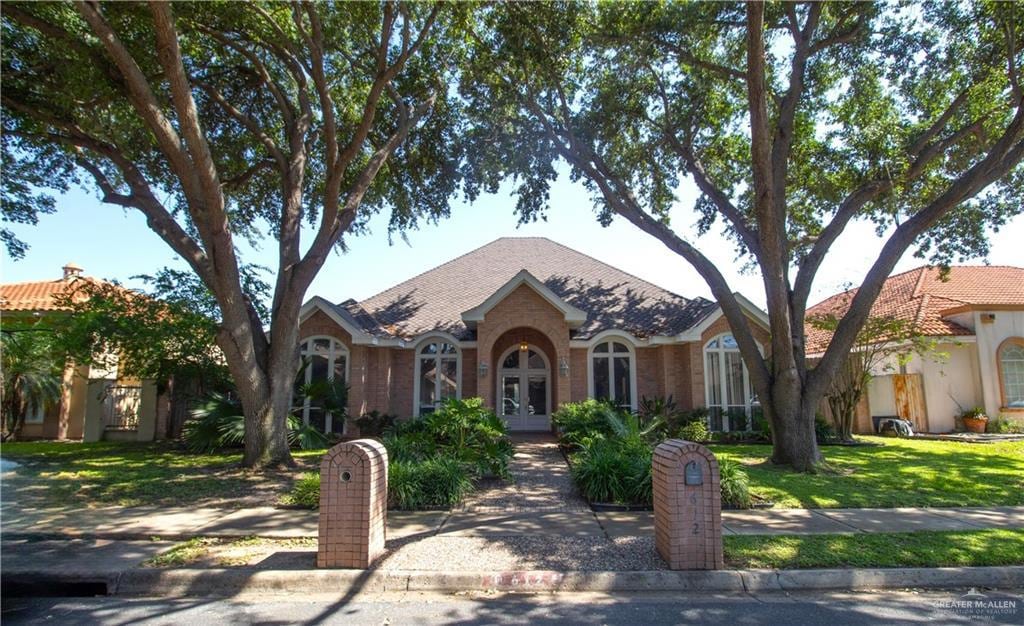 612 Cardinal Ave, Mcallen, TX 78504 - tudor home featuring french doors and a front yard