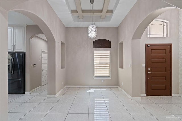 tiled foyer featuring beamed ceiling, an inviting chandelier, and coffered ceiling