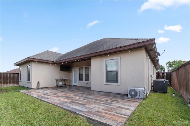 rear view of house with ac unit, central air condition unit, a yard, and a patio