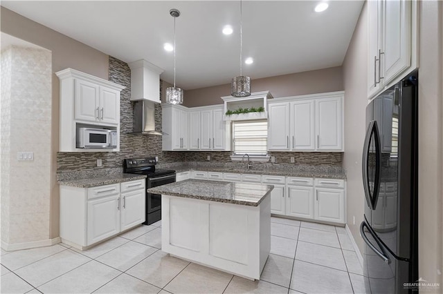 kitchen with white cabinetry, black fridge, stainless steel range with electric stovetop, and a kitchen island