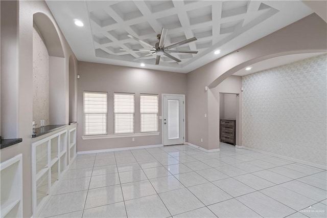 interior space featuring ceiling fan, light tile patterned flooring, beam ceiling, and coffered ceiling