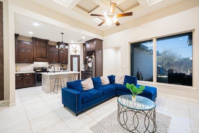 tiled living room with beamed ceiling, ceiling fan, coffered ceiling, and sink