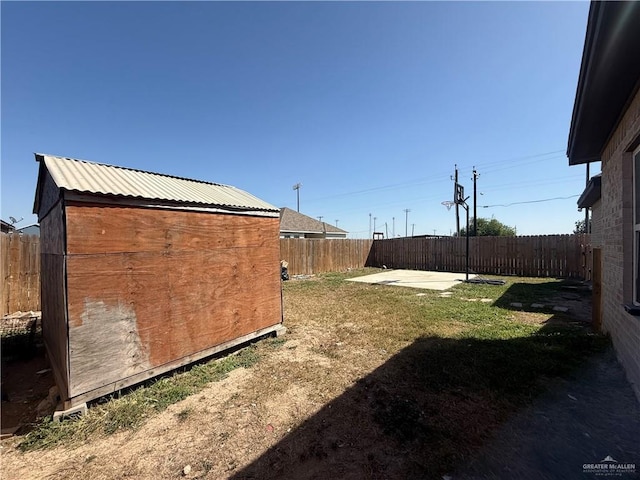 view of yard with a fenced backyard, a shed, a patio area, and an outdoor structure