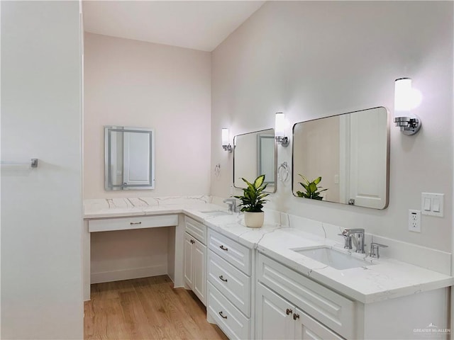 bathroom featuring double vanity, a sink, and wood finished floors