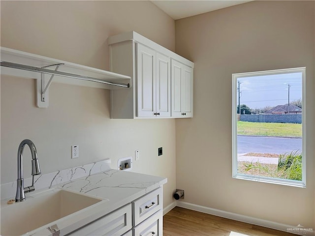 laundry area featuring cabinet space, baseboards, a sink, washer hookup, and electric dryer hookup