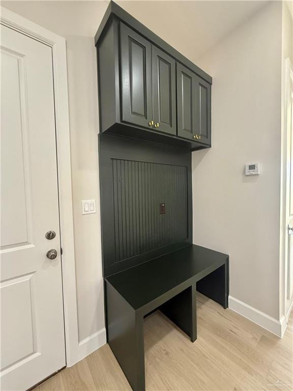 mudroom featuring light wood finished floors and baseboards