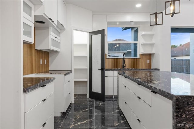 3009 E Bella Vista Ave, Alton, TX 78573 - kitchen with white cabinets, marble finish floor, dark stone countertops, and a wealth of natural light