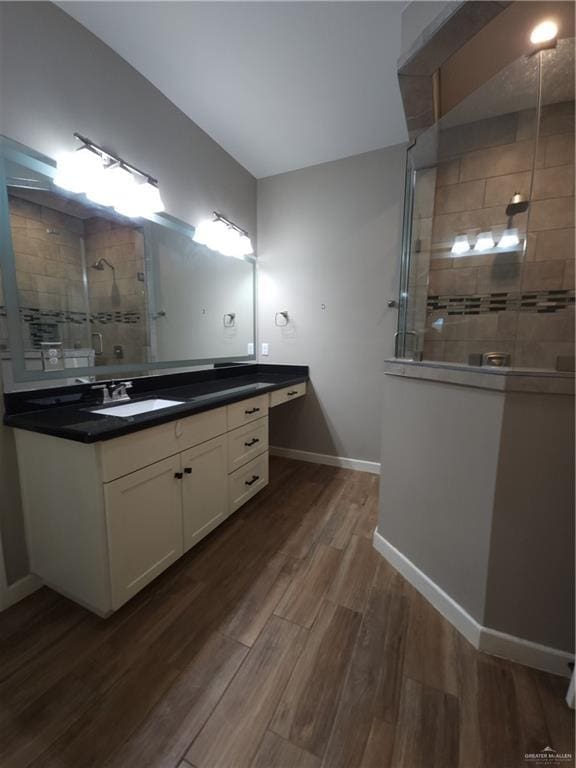 bathroom featuring vanity, wood-type flooring, and tiled shower