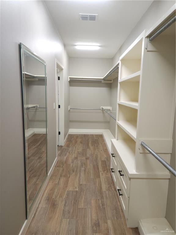 walk in closet with hardwood / wood-style floors