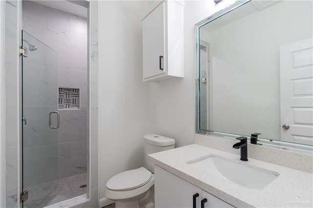 bathroom featuring vanity, a shower stall, and toilet