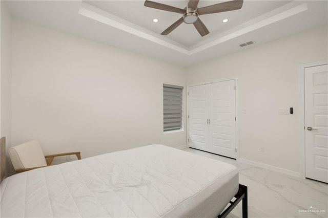 bedroom with marble finish floor, a raised ceiling, visible vents, and recessed lighting