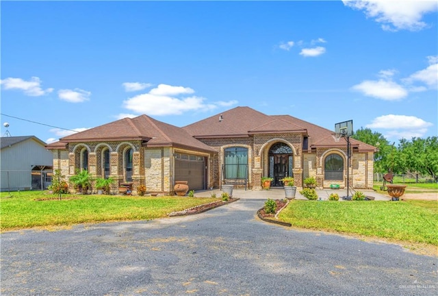 mediterranean / spanish house featuring a front yard and a garage