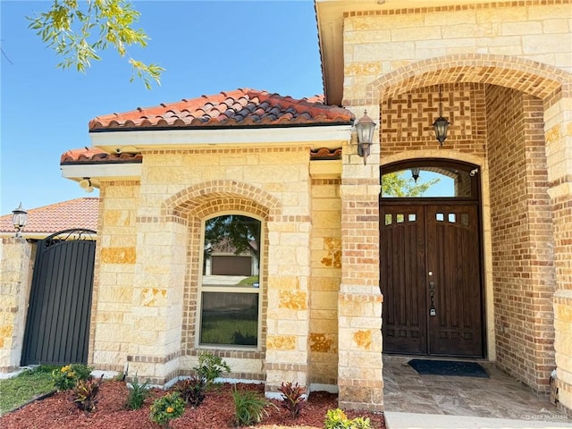 1813 Harvard Ave, Mcallen, TX 78504 - doorway to property featuring a tiled roof, a gate, and brick siding