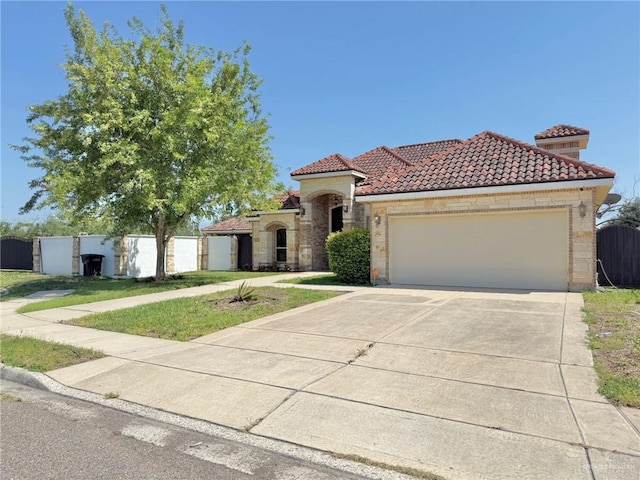 1813 Harvard Ave, Mcallen, TX 78504 - mediterranean / spanish-style house with a tile roof, concrete driveway, an attached garage, and fence
