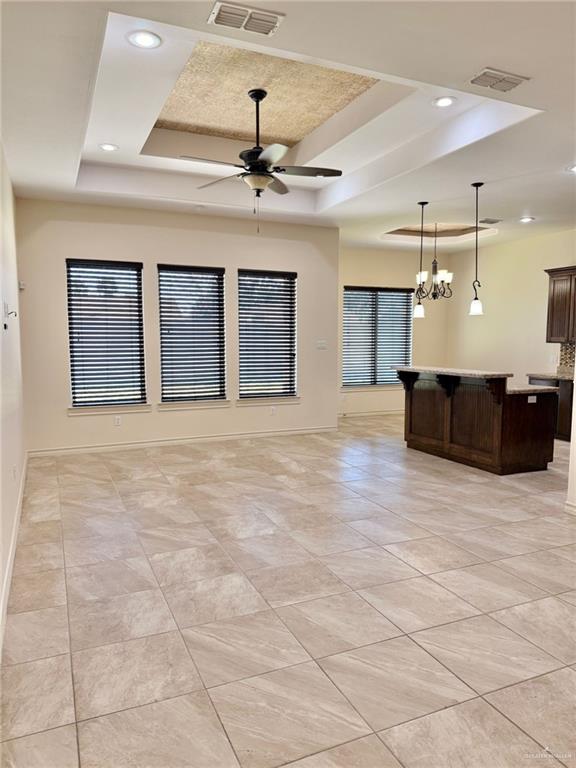 1813 Harvard Ave, Mcallen, TX 78504 - unfurnished living room with a tray ceiling, a ceiling fan, recessed lighting, baseboards, and light tile patterned flooring