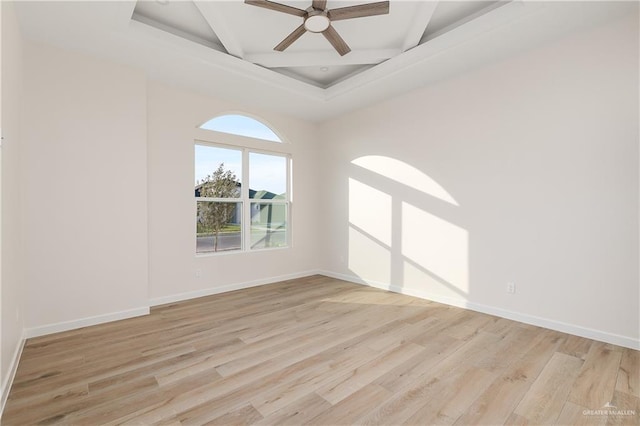 spare room with ceiling fan, light hardwood / wood-style floors, and beam ceiling