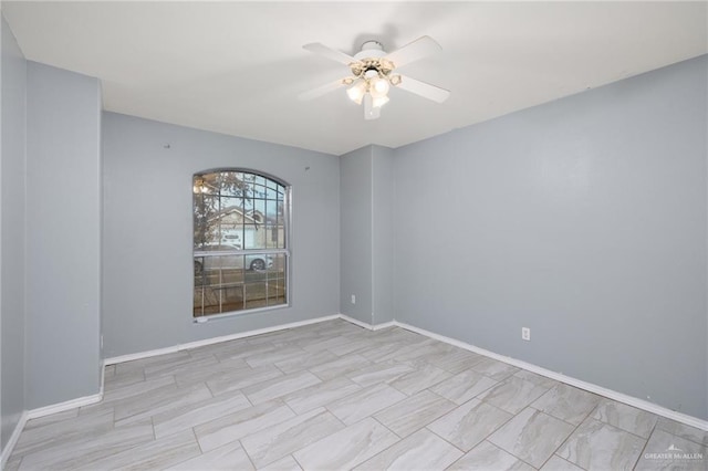 empty room featuring baseboards and a ceiling fan